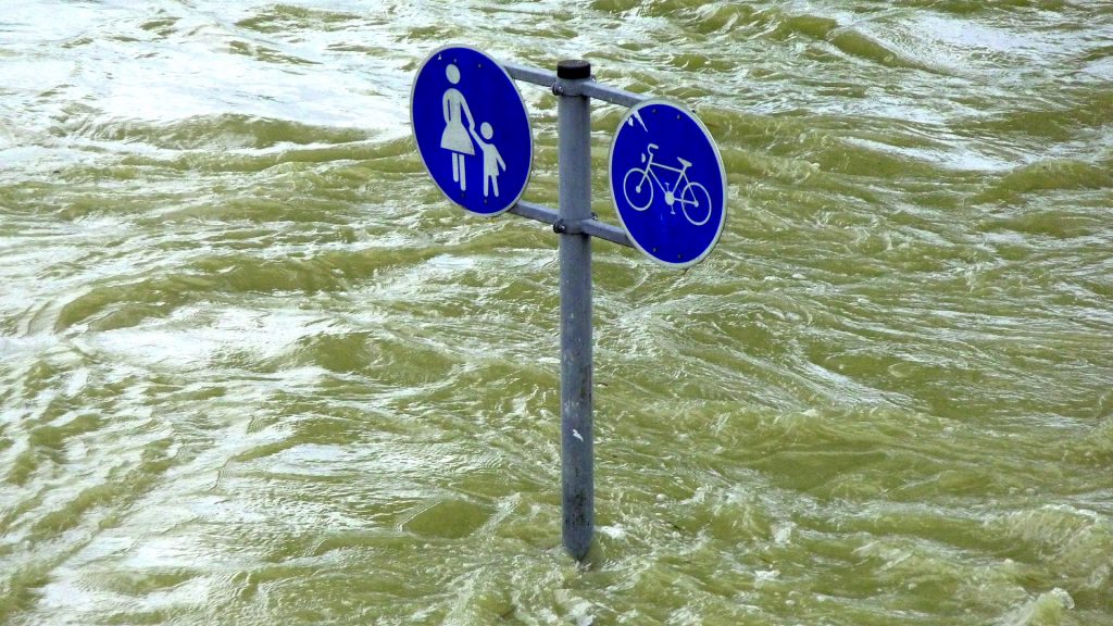 flooded foot- and bike path with trafic signs/ überfluteter Geh- und Radweg, Verkehrszeichen